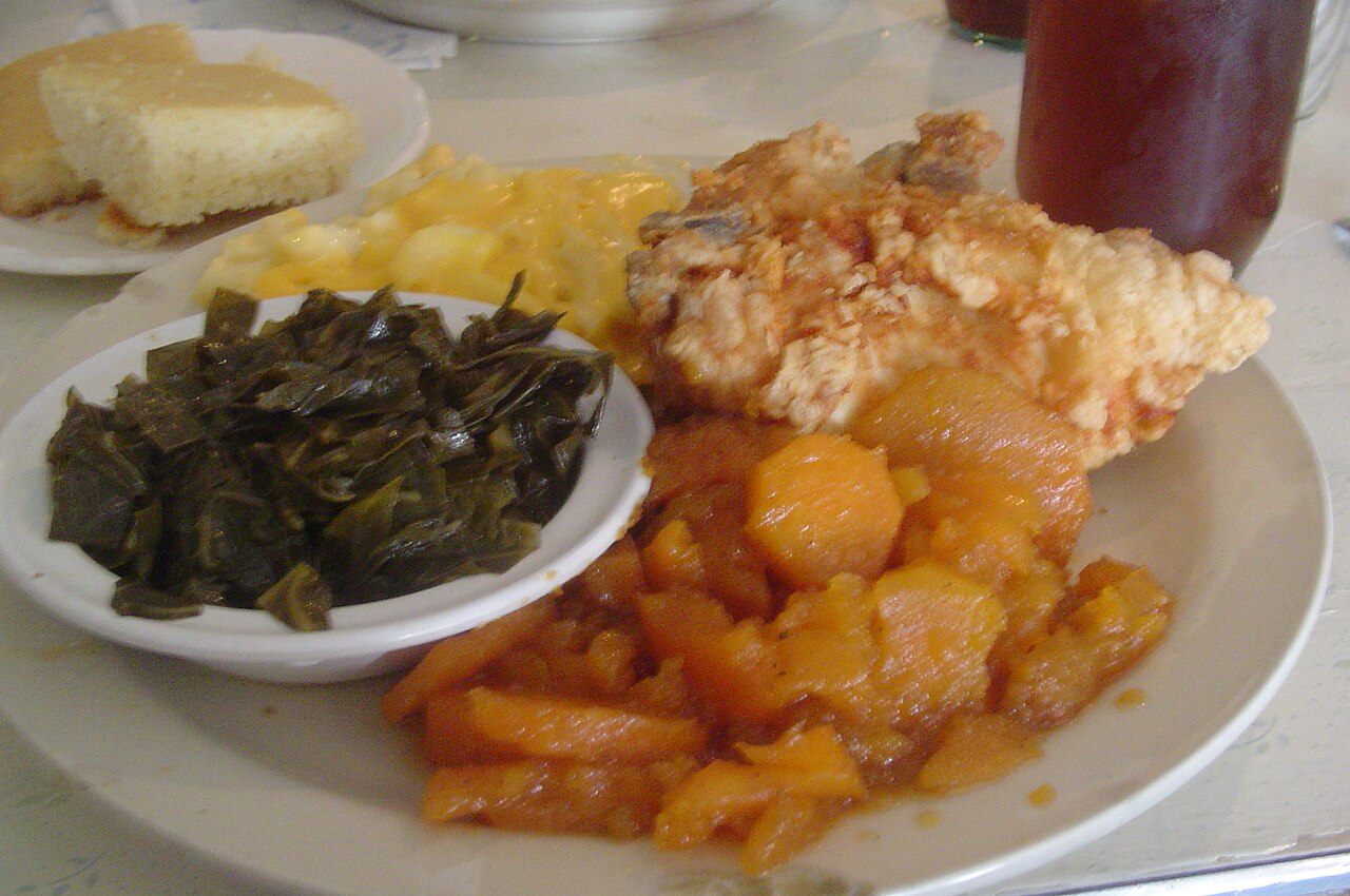 A full soul food plate with fried chicken, collard greens and peach cobbler